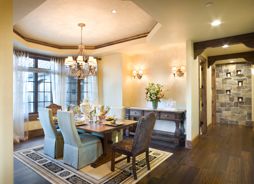 Aménagement d'une salle à manger classique avec un mur beige et parquet foncé.