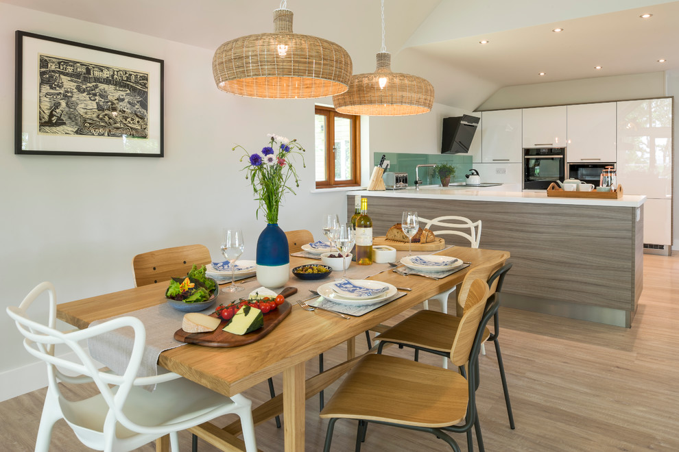 Imagen de comedor de cocina marinero grande con paredes blancas, suelo de madera clara y suelo beige