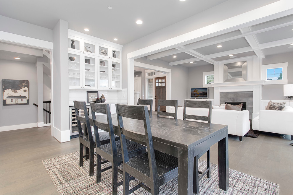 Inspiration for a large classic kitchen/dining room in Seattle with grey walls, medium hardwood flooring, a standard fireplace and a tiled fireplace surround.