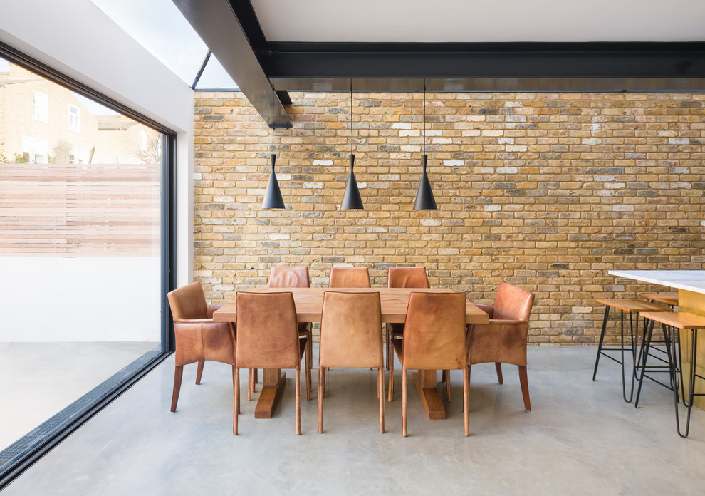 Cette photo montre une salle à manger ouverte sur la cuisine chic avec un mur marron, aucune cheminée et un sol gris.