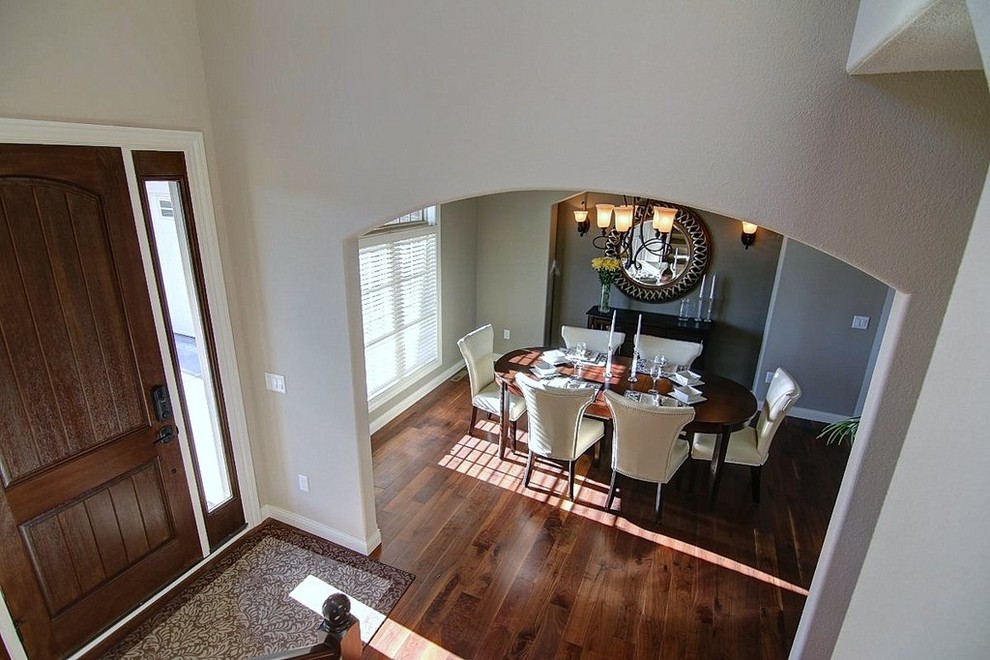Inspiration pour une salle à manger ouverte sur la cuisine traditionnelle de taille moyenne avec un mur gris et un sol en bois brun.