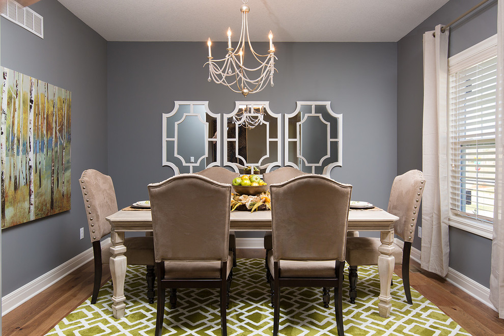 Cette photo montre une salle à manger ouverte sur la cuisine chic de taille moyenne avec un mur gris et parquet clair.