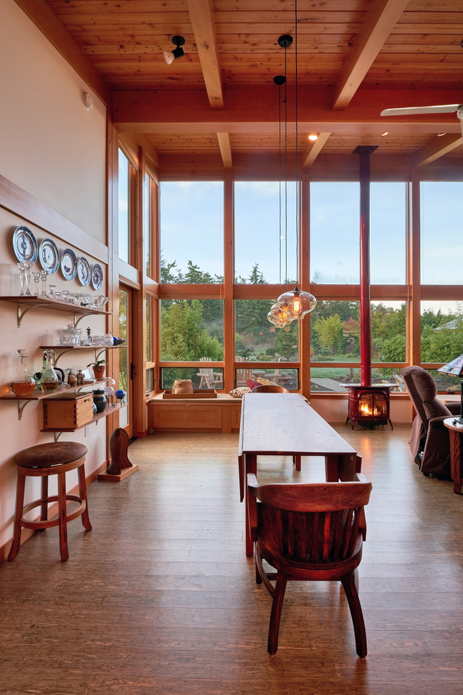 Photo of a medium sized contemporary open plan dining room in Seattle with a wood burning stove, white walls and medium hardwood flooring.
