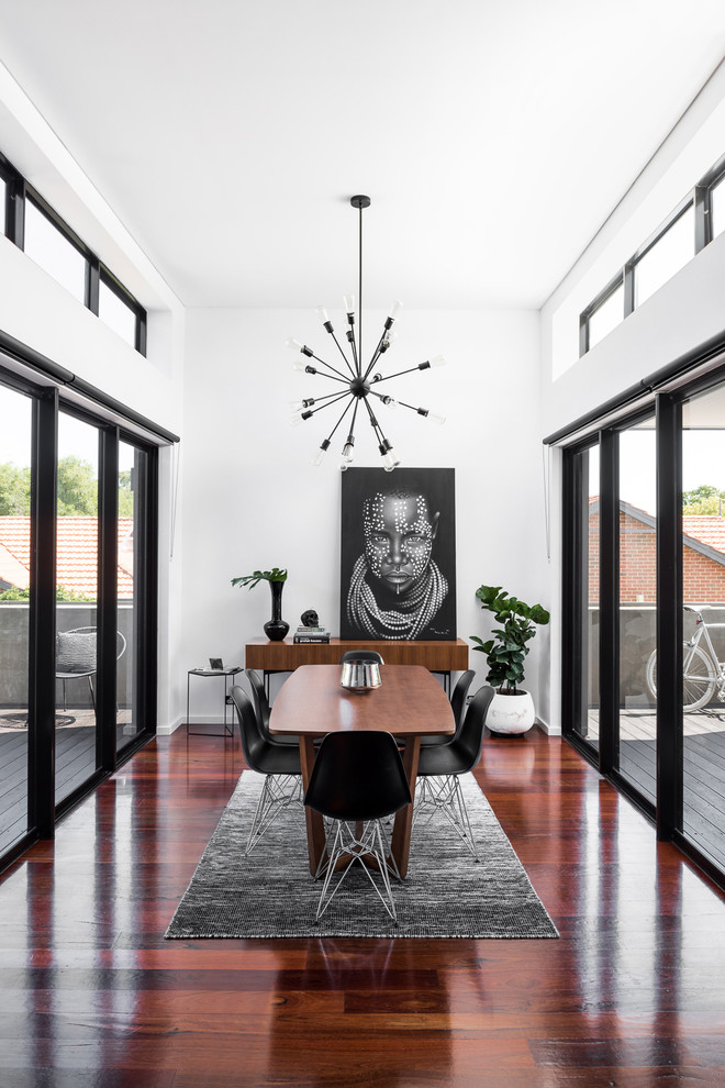 Geschlossenes Modernes Esszimmer mit weißer Wandfarbe, dunklem Holzboden und braunem Boden in Perth