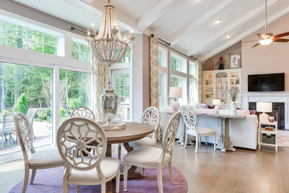 Mittelgroßes Shabby-Style Esszimmer mit lila Wandfarbe, braunem Holzboden, Kamin, Kaminumrandung aus Stein und braunem Boden in Sonstige