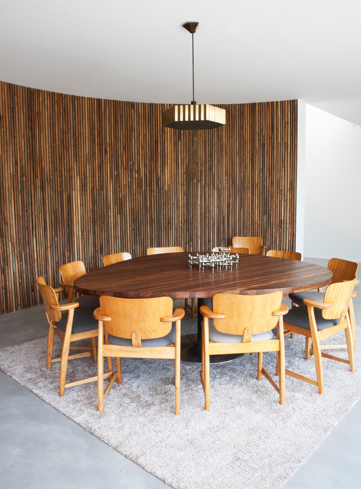 Diseño de comedor minimalista extra grande abierto con paredes blancas y suelo de cemento