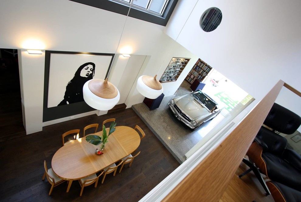 Cette photo montre une grande salle à manger ouverte sur la cuisine tendance avec un mur marron, sol en béton ciré, une cheminée double-face, un manteau de cheminée en béton et un sol gris.