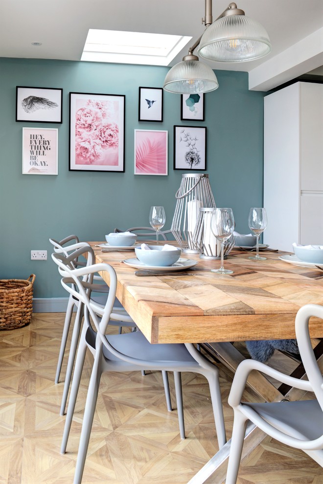 Idée de décoration pour une salle à manger nordique avec un mur vert, parquet clair et un sol beige.