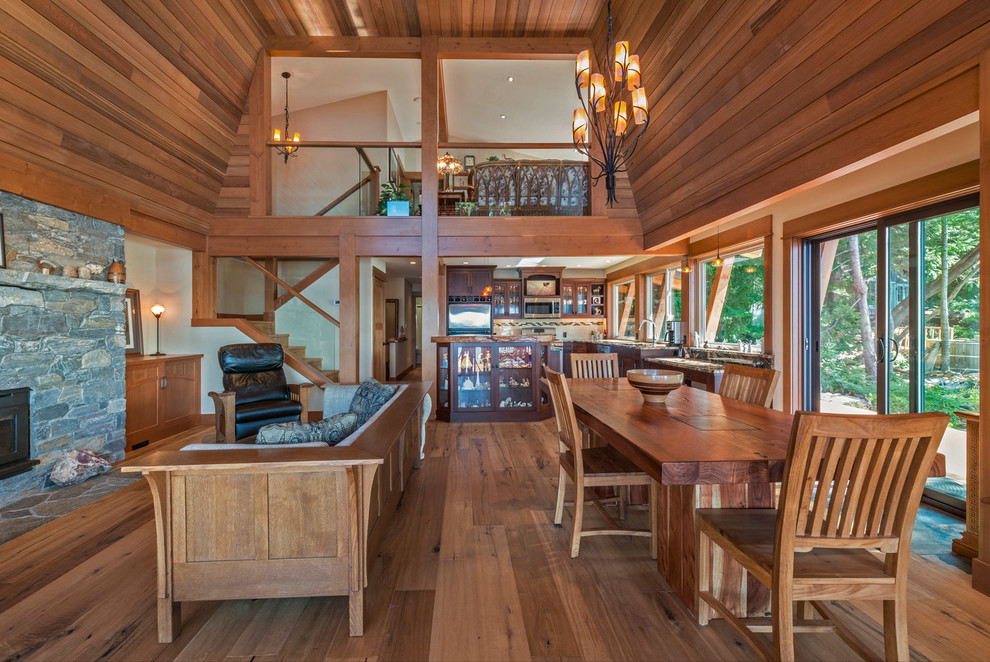 Foto di una sala da pranzo stile rurale con pavimento in legno massello medio e stufa a legna