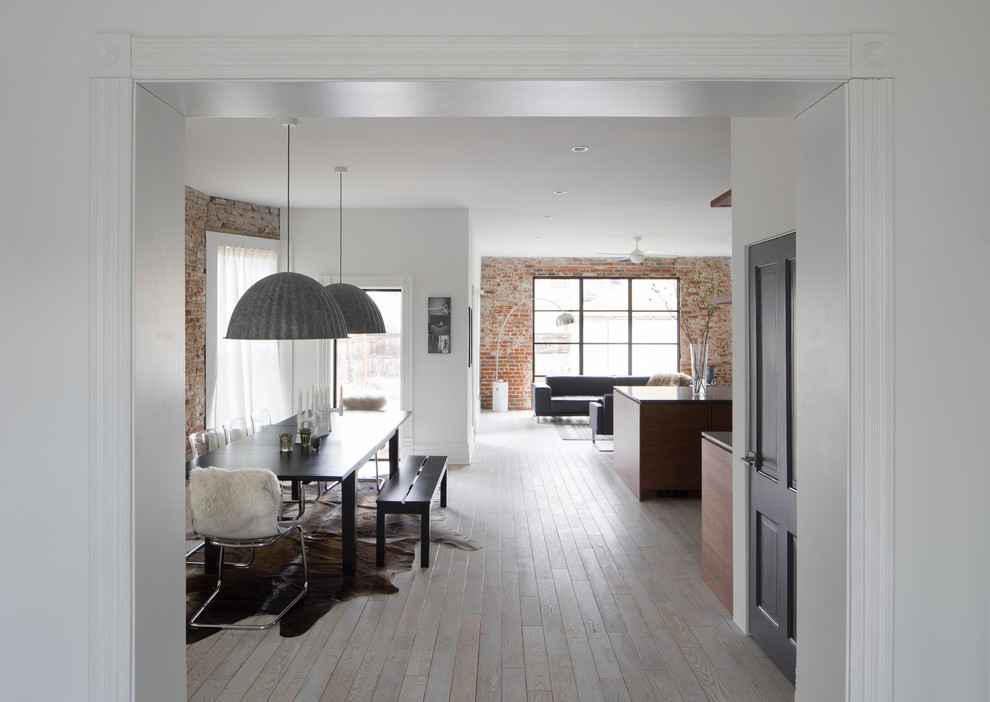 Cette photo montre une salle à manger ouverte sur la cuisine tendance de taille moyenne avec un mur blanc, parquet clair, aucune cheminée et un sol beige.