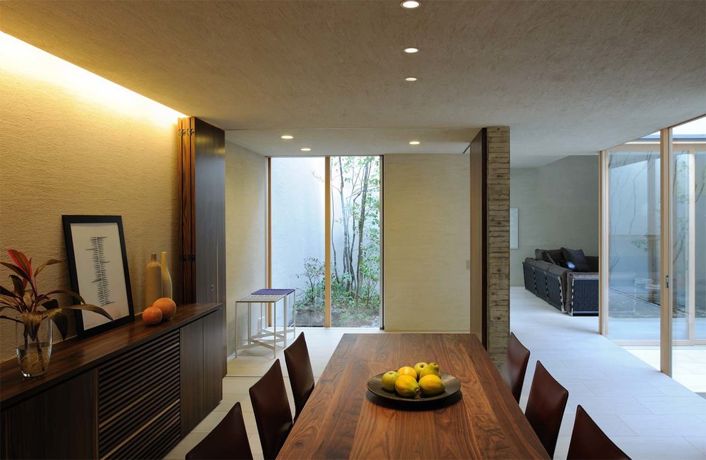 Contemporary dining room in Osaka with beige walls and limestone flooring.
