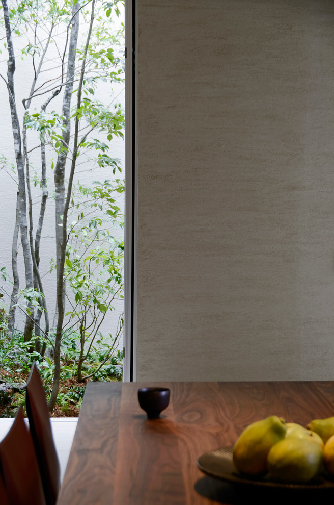 Cette image montre une salle à manger design avec un mur beige et un sol en calcaire.