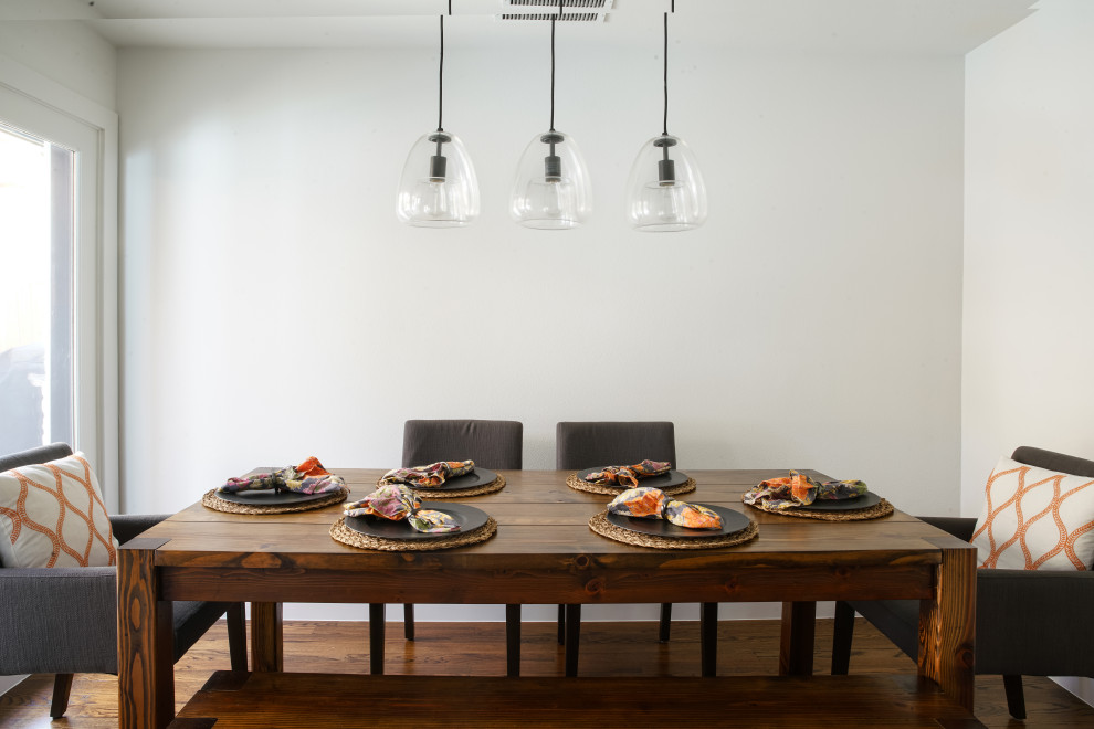 Ispirazione per una piccola sala da pranzo aperta verso la cucina moderna con pareti bianche, parquet scuro e pavimento marrone