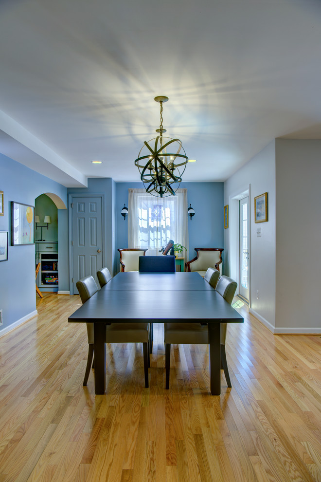 Idée de décoration pour une salle à manger ouverte sur la cuisine tradition avec un mur bleu.
