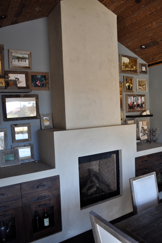 Cette photo montre une salle à manger tendance fermée et de taille moyenne avec un mur gris et une cheminée standard.