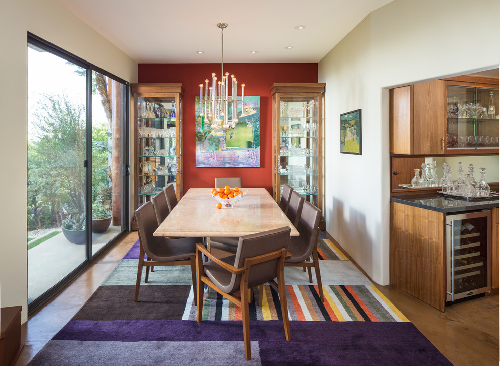 Ispirazione per una sala da pranzo aperta verso la cucina design di medie dimensioni con pareti rosse, nessun camino e pavimento in cemento