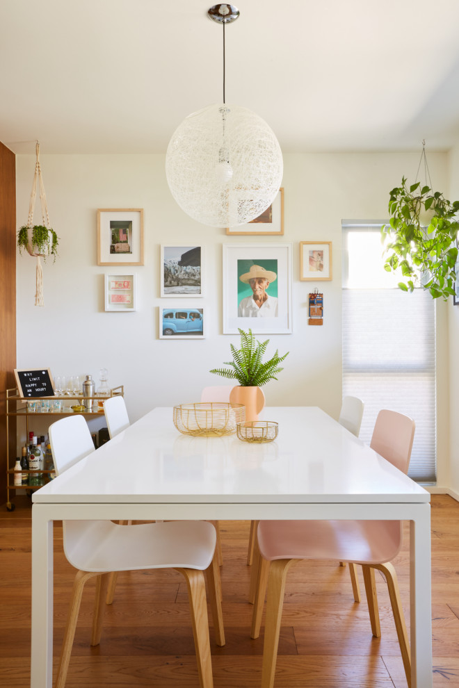 На фото: кухня-столовая в стиле модернизм с белыми стенами, светлым паркетным полом и коричневым полом с