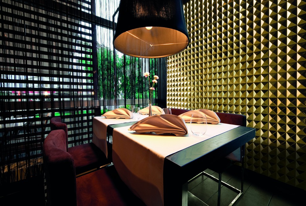 Esempio di una sala da pranzo aperta verso il soggiorno contemporanea di medie dimensioni con pareti gialle, parquet scuro e pavimento nero