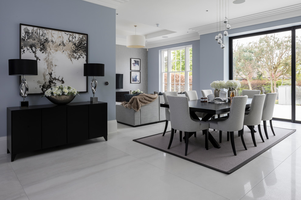 This is an example of a large contemporary open plan dining room in London with grey walls and white floors.