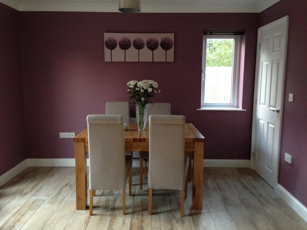 Foto di una sala da pranzo aperta verso la cucina con pareti viola, pavimento in gres porcellanato e nessun camino