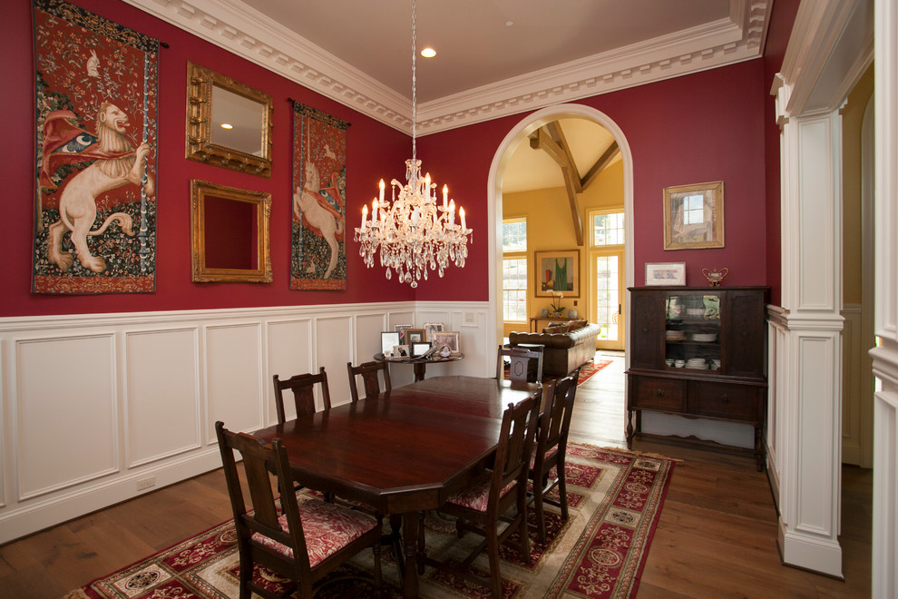 Exemple d'une grande salle à manger victorienne fermée avec un mur rouge, un sol en bois brun et aucune cheminée.
