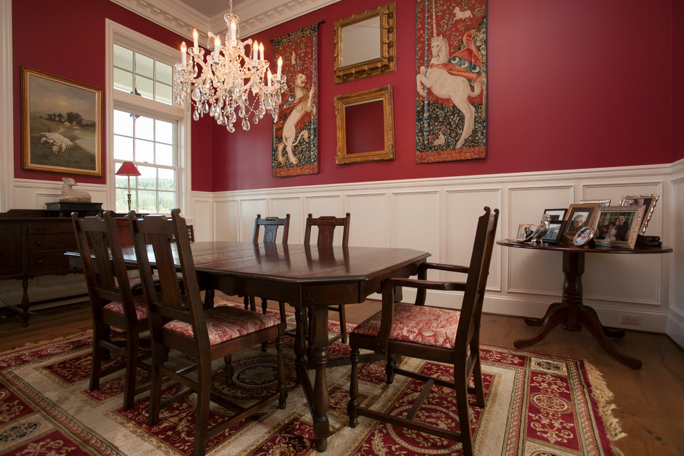 Réalisation d'une grande salle à manger victorienne fermée avec un mur rouge, un sol en bois brun et aucune cheminée.