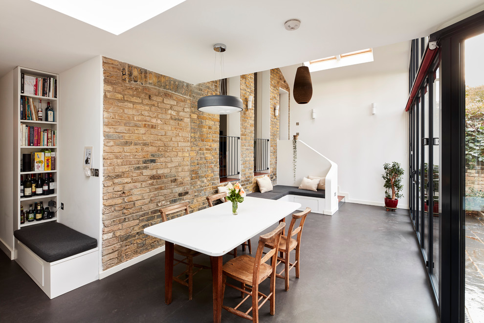 Cette photo montre une salle à manger ouverte sur le salon tendance de taille moyenne avec un mur blanc, aucune cheminée et un sol gris.