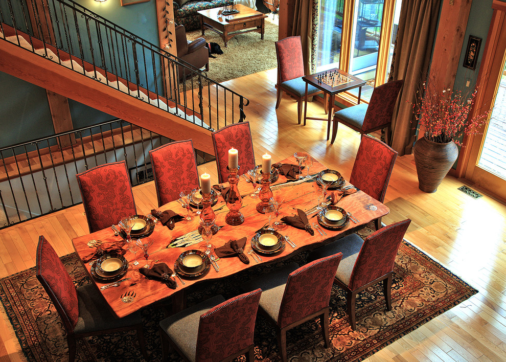 Idee per una sala da pranzo aperta verso il soggiorno rustica di medie dimensioni con pareti blu, pavimento in legno massello medio e pavimento marrone