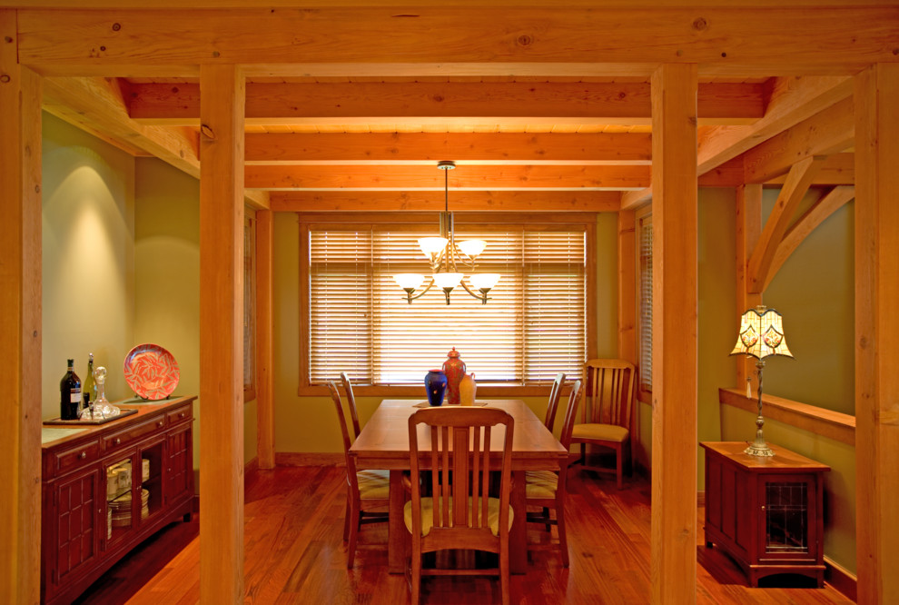 Esempio di una sala da pranzo aperta verso il soggiorno stile rurale di medie dimensioni con pareti verdi, pavimento in legno massello medio e nessun camino