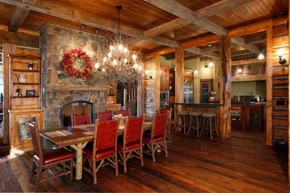 Large elegant dark wood floor kitchen/dining room combo photo in Other with brown walls, a standard fireplace and a stone fireplace