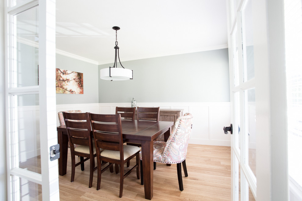 Aménagement d'une salle à manger classique fermée et de taille moyenne avec un mur vert et un sol en bois brun.