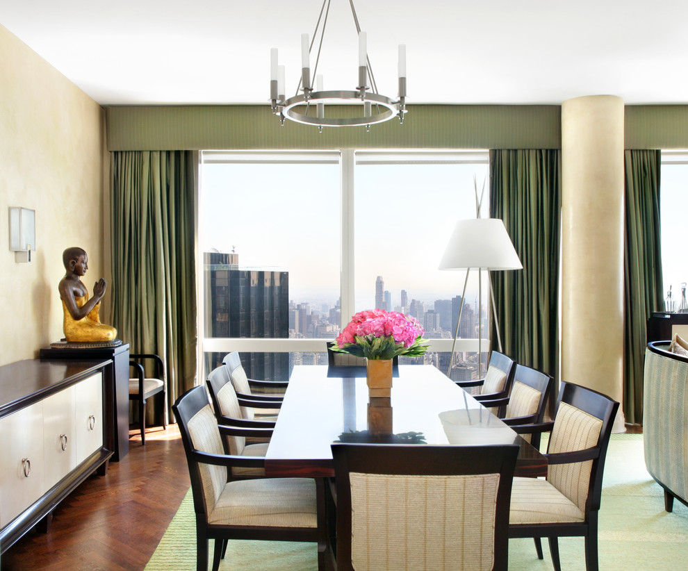 This is an example of a large contemporary open plan dining room in New York with beige walls, medium hardwood flooring and feature lighting.