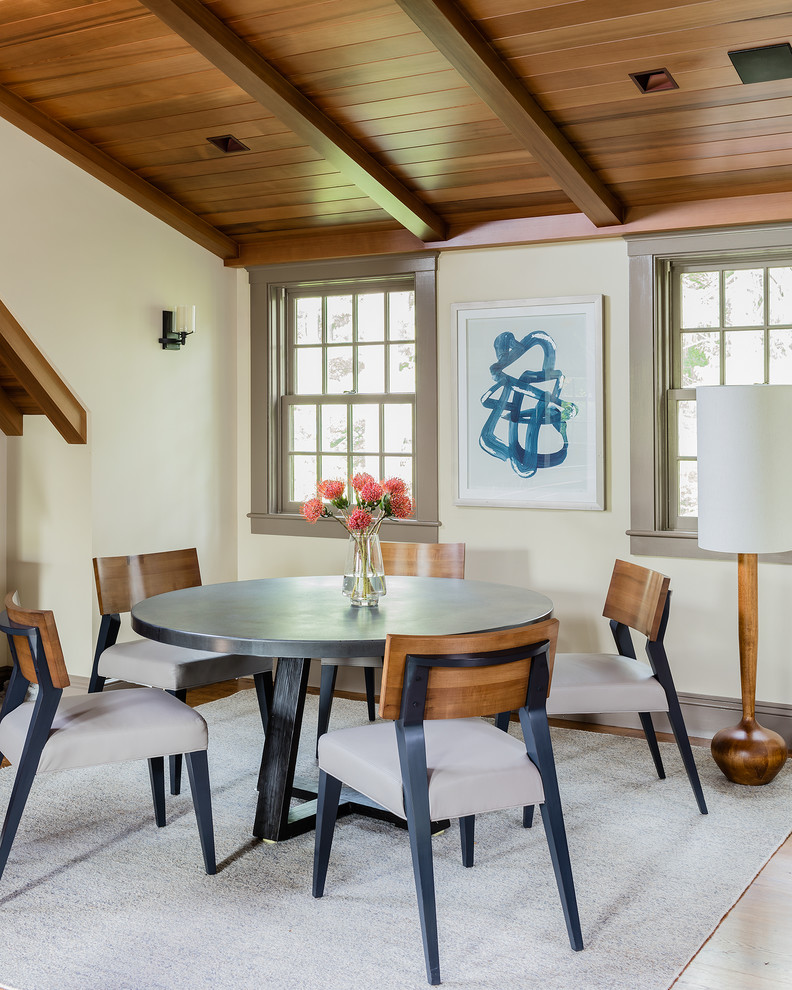Modelo de comedor clásico renovado con paredes blancas, suelo de madera en tonos medios y suelo marrón