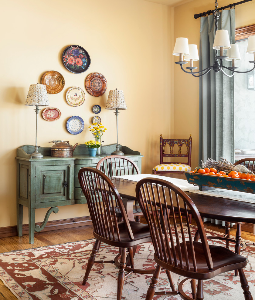 Dining room in Denver with yellow walls, medium hardwood flooring and brown floors.