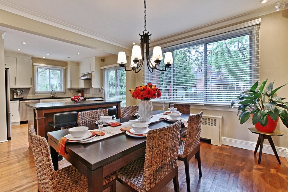 Esempio di una piccola sala da pranzo aperta verso la cucina minimal con pareti beige e pavimento in legno massello medio