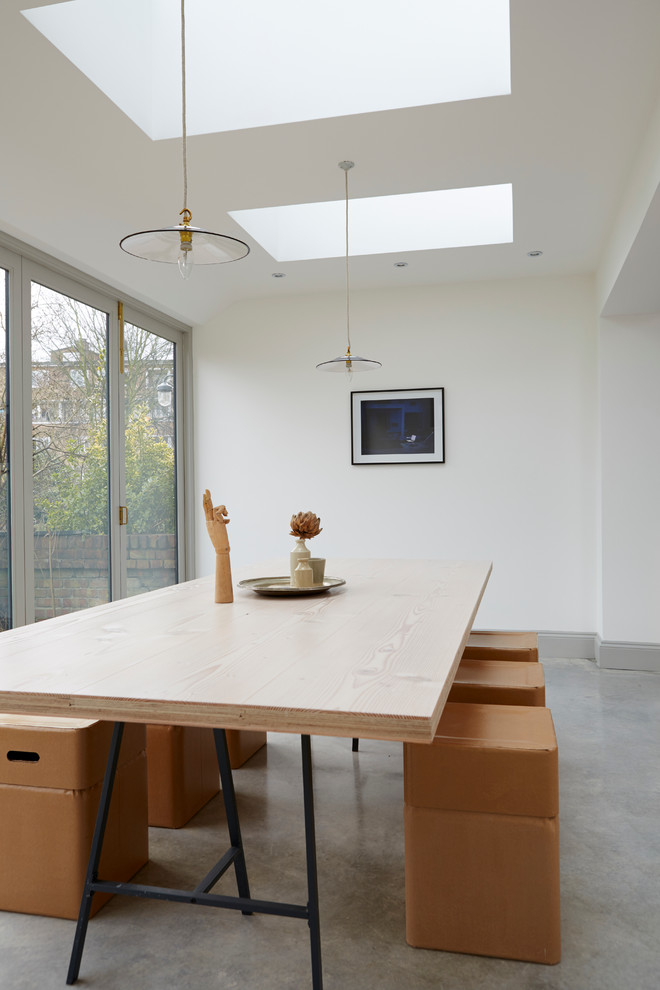 Источник вдохновения для домашнего уюта: большая гостиная-столовая в современном стиле с белыми стенами и бетонным полом без камина