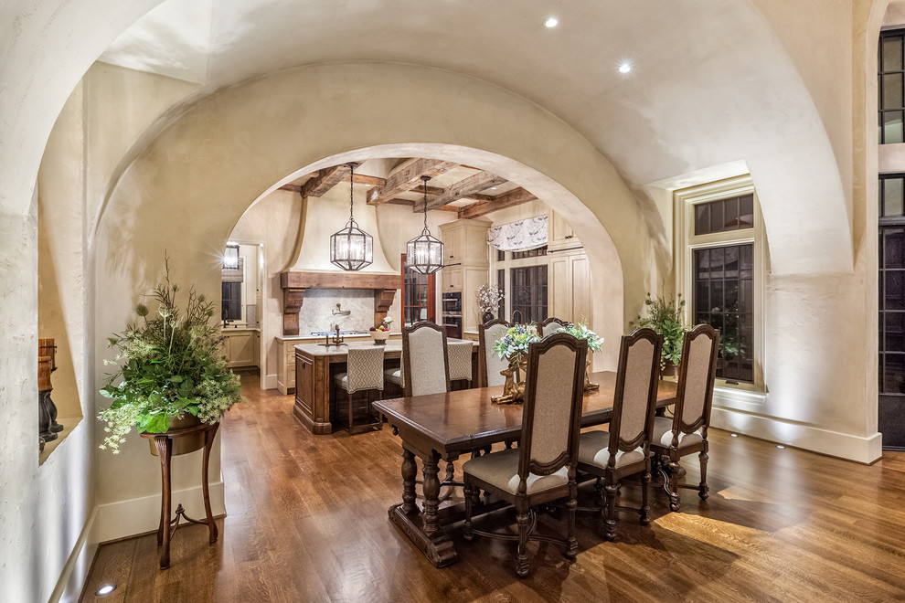 Cette photo montre une grande salle à manger ouverte sur la cuisine chic avec un sol en bois brun, un mur beige et aucune cheminée.