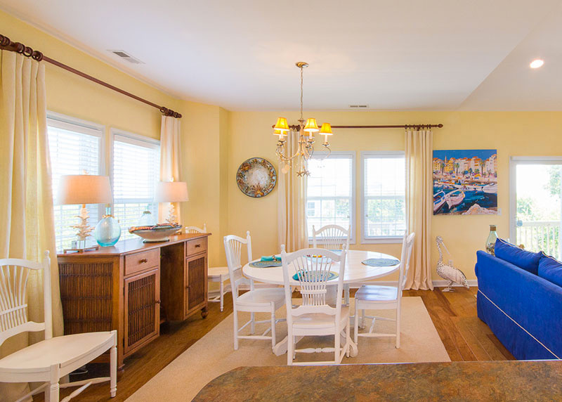 Inspiration for a medium sized beach style open plan dining room in Other with yellow walls, medium hardwood flooring, no fireplace and brown floors.