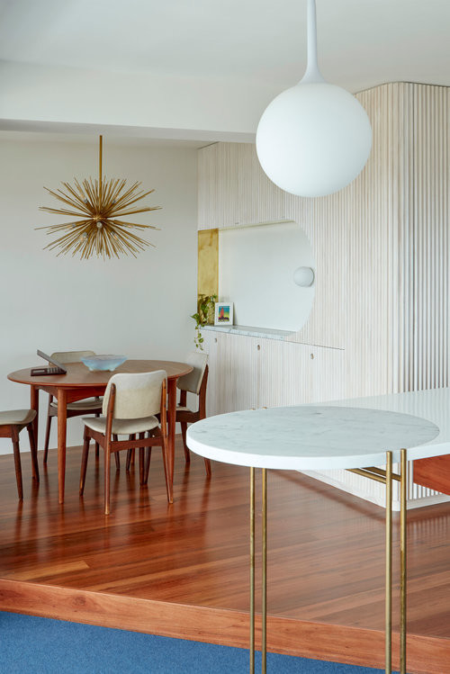 Foto di una piccola sala da pranzo aperta verso il soggiorno minimalista con pareti bianche, pavimento in legno massello medio e pavimento marrone