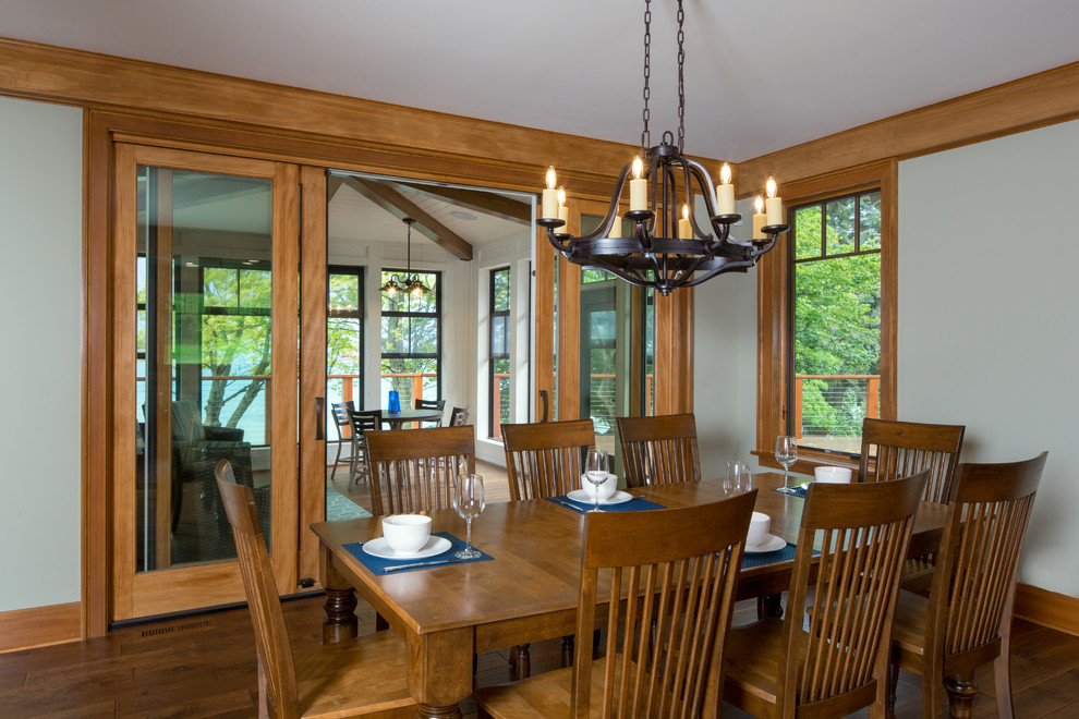 Foto di una grande sala da pranzo aperta verso il soggiorno stile americano con pareti verdi, pavimento in legno massello medio e pavimento marrone