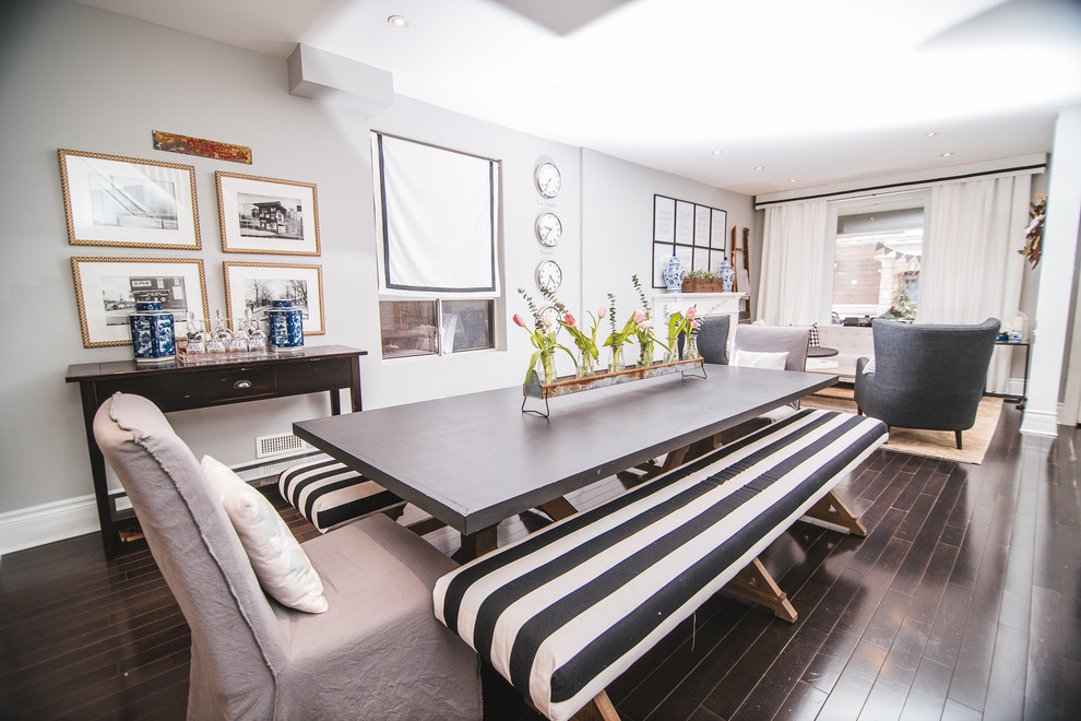 Kitchen/dining room combo - small country dark wood floor and brown floor kitchen/dining room combo idea in Toronto with gray walls, a standard fireplace and a wood fireplace surround