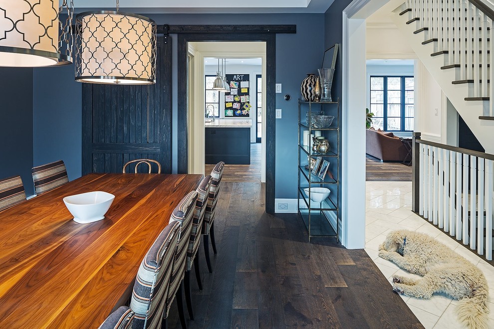 Immagine di una grande sala da pranzo aperta verso la cucina classica con pareti blu e parquet scuro