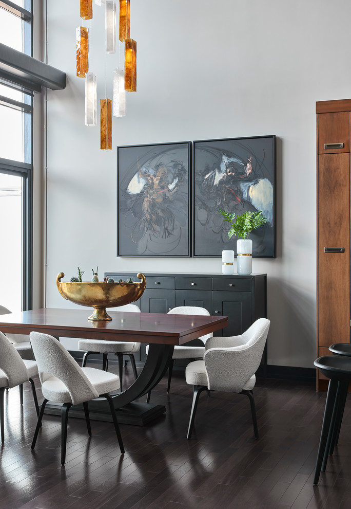 На фото: гостиная-столовая среднего размера в стиле неоклассика (современная классика) с темным паркетным полом, коричневым полом и серыми стенами без камина с