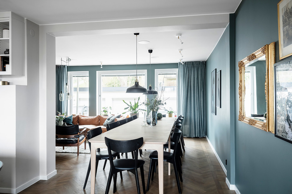 Modelo de comedor de cocina escandinavo de tamaño medio con paredes azules, suelo de madera oscura y suelo marrón