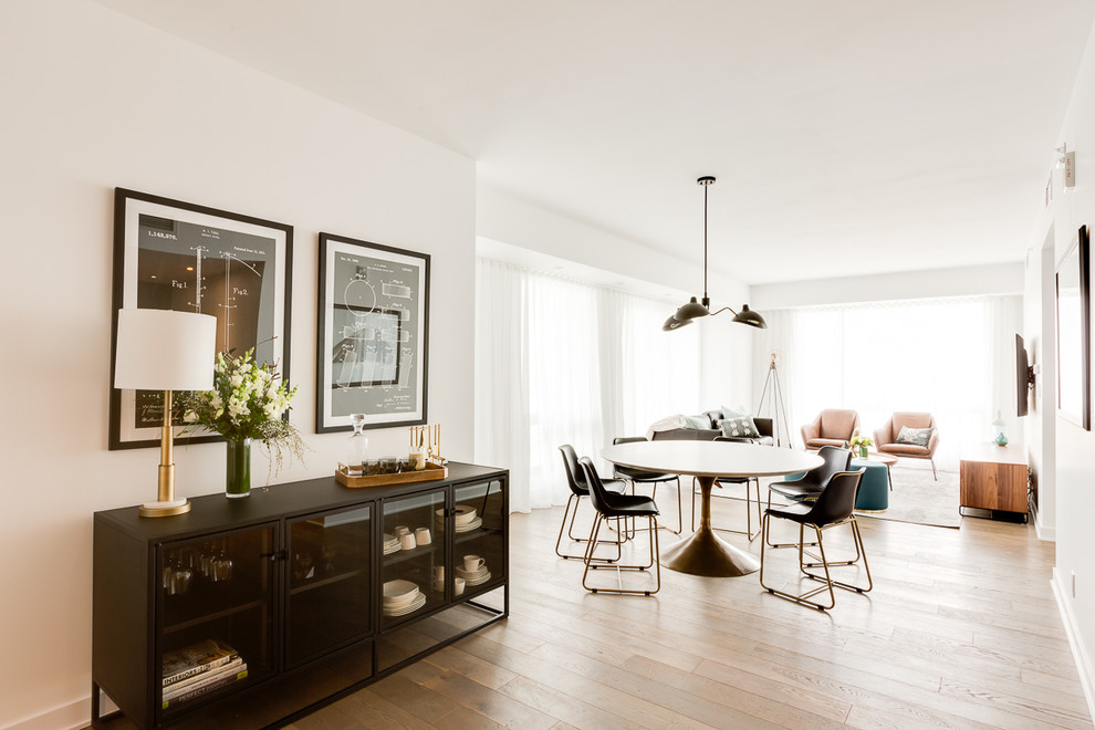 Esempio di una sala da pranzo aperta verso il soggiorno minimal di medie dimensioni con pareti bianche e pavimento in legno massello medio