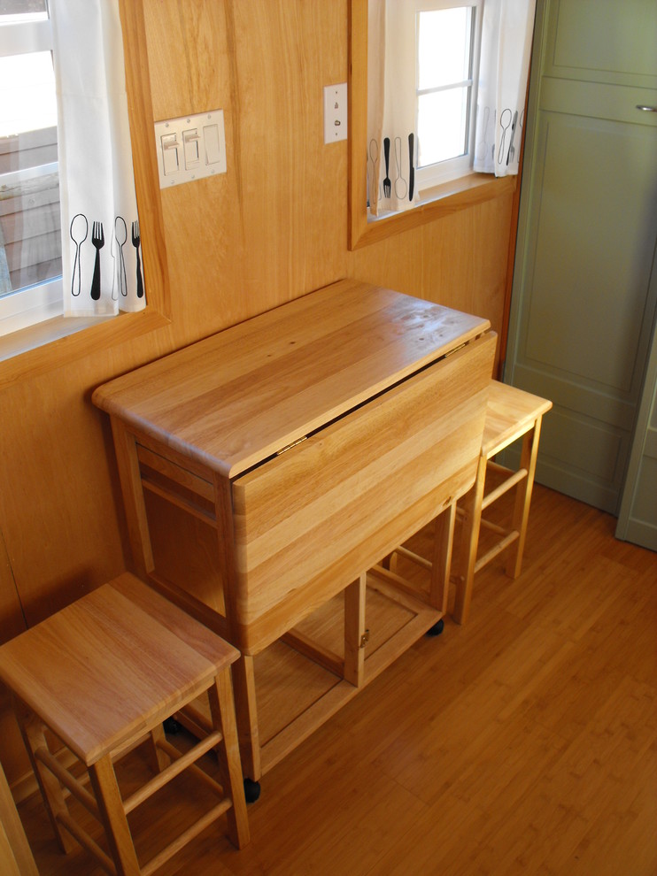 Immagine di una piccola sala da pranzo aperta verso la cucina tradizionale con pareti marroni, pavimento in bambù e nessun camino