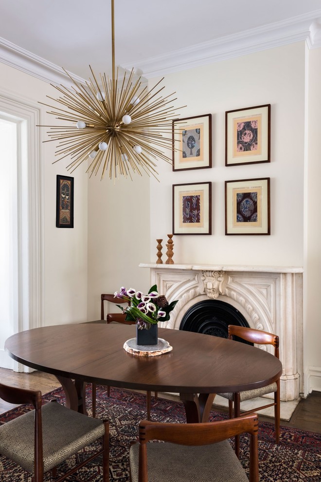 Photo of a traditional enclosed dining room in New York with beige walls and a standard fireplace.