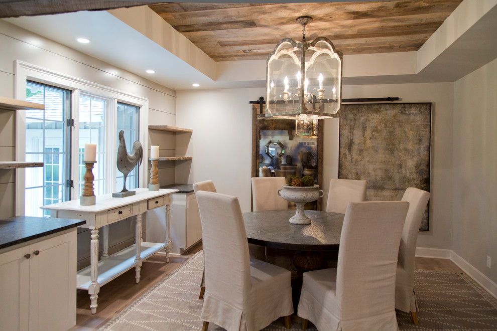 Esempio di una grande sala da pranzo aperta verso il soggiorno country con pareti grigie, pavimento in legno massello medio e pavimento marrone