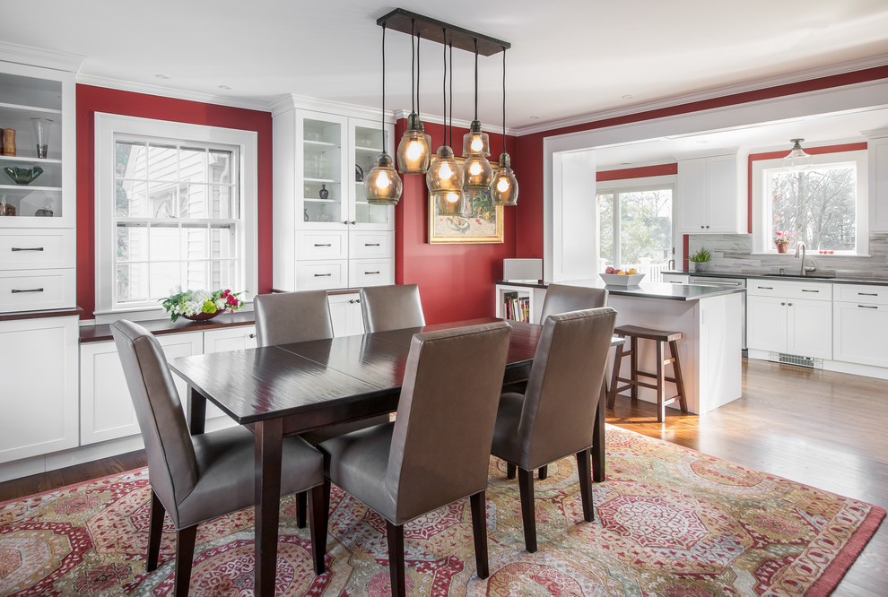 На фото: кухня-столовая в стиле неоклассика (современная классика) с красными стенами, паркетным полом среднего тона и коричневым полом