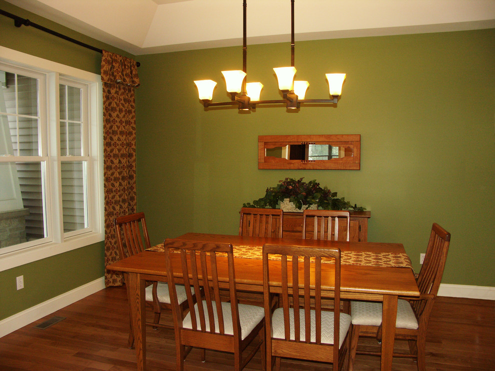 Esempio di una sala da pranzo stile americano di medie dimensioni e chiusa con pareti verdi e pavimento in legno massello medio